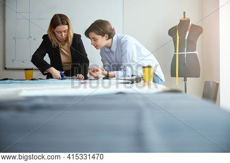 Fashion Expert Teaching Trainee On Proper Cutting Of Fabric
