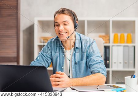 Workplace of freelance worker or sudent at home office. Young man works using computer and other devices. Remote job.