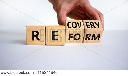 Recovery And Reform Symbol. Businessman Turns Cubes And Changes The Word 'recovery' To 'reform'. Bea