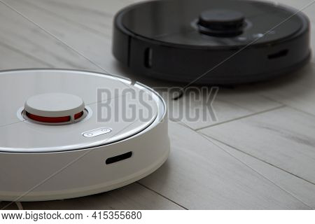 Black And White Robot Vacuum Cleaners Automatically Clean The Floor. Unpopulated Technologies