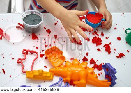 A Childs Hands Play With Bright Kinetic Sand On A White Table. An Educational Game Of Kinetic Sand W