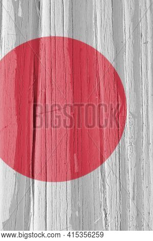 Fragment Of Japan Flag On A Dry Wooden Surface, Cracked With Age. Light Pale Faded Paint. Vertical B