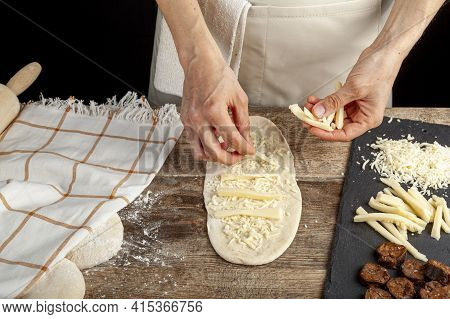 A Flattened Dough On Wood Kitchen Countertop. A Bread Making Concept Image With Loafs,  Cheese And S