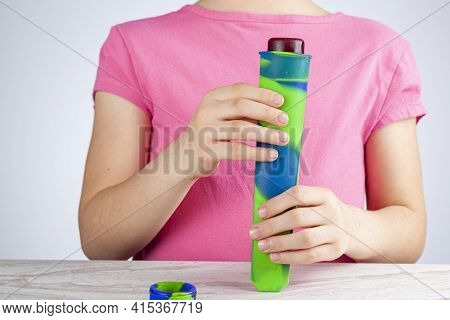 A Cute Little Caucasian Girl Is Squeezing Frozen Popsicle Berry Sorbet Out Of The Silicon Reusable C