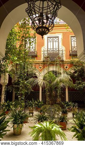 Seville, Spain, 07-12-2010: Ornamental Historic Courtyard Garden Interior Design With Potted Palm Tr
