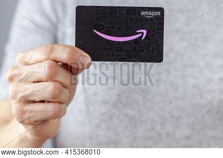 Clarksburg, Md, Usa 02-25-2021: A Caucasian Woman Is Holding An Amazon.com Gift Card (black Backgrou