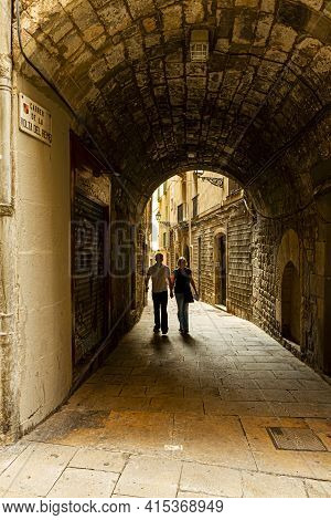 Barcelona, Spain 05-01-2010: A Couple Holding Hands In
Carrer De La Volta Del Remei,  Narrow Stone A