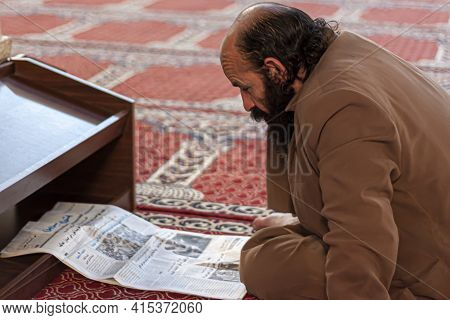 Damascus, Syria, 03/28/2010: A Middle Aged Bearded Arabic Man Is Sitting Crosslegged On The Carpeted