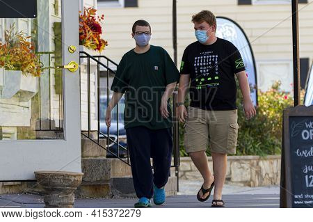 Ellicott City, Md, Usa 10/07/2020: Two Young Men Both Wearing Face Masks Due To Covid-19 Are Walking