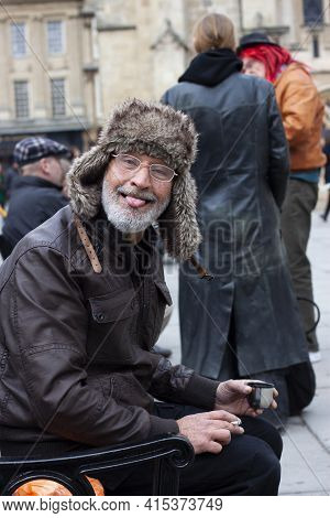 Bath, Uk 03/06/2010:  A Funny Old Man Who Is Holding A Metal Cup Of Hot Drink And A Cigarette While 