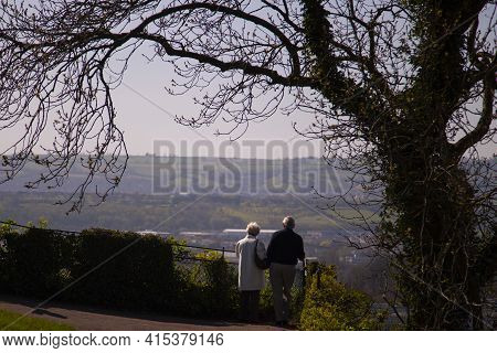 Well Dressed Elderly Couple Is Enjoying The Panoramic View Of Bristol And The Countryside,  As Seen 