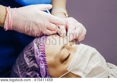 Surgeon In Gloves Gives Injection Of Local Anesthesia To Patient Before Laser Removing Mole, Closeup