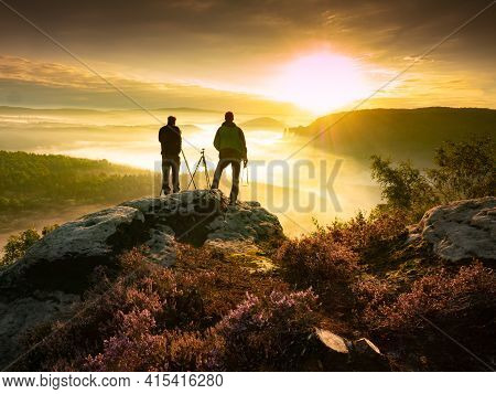 Two Landscape Photographers Taking Photos Of Mountain Range During Sunrise And Heavy Mist  In Beauti