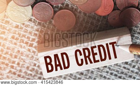 Bad Credit Text On Wooden Block And Coins On Burlap Canvas. Crisis Times Unpaid Loand And Credits Fi
