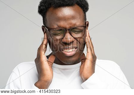 Sick African American Millennial Man Suffering From Tinnitus, Throbbing Earache, Tired Of Noise. Irr