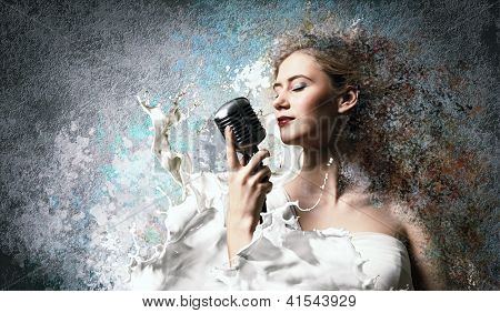 닫힌 눈 색 배경에 대해 마이크를 들고 여자 금발가 수의 이미지