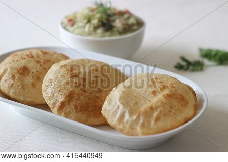 Deep Fried Indian Flat Bread Served With Mixed Vegetable Curry In A Coconut Cashew Gravy