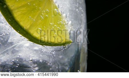 Macro Close-up, Refreshing Soda Tonic Fizzy Water, Lime In Glass, Ice. Slice Of Lemon, Mineral Bubbl