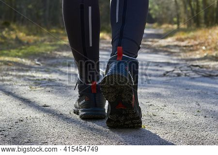 Curonian Spit, Russia - December 19, 2020. Women's Legs In Reebok Trekking Boots. Walk In The Woods