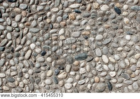 An Old Pebblestone Road Cobbled With Natural Stones As A Background