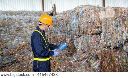 Engineer Checking Second Hand Plastic Bottles In The Background At Waste Recycling Factory,industry 