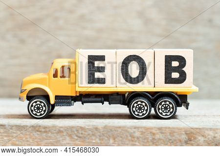 Toy Truck Hold Alphabet Letter Block In Word Eob (abbreviation Of End Of Business) On Wood Backgroun