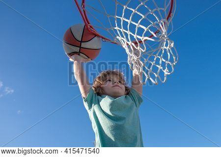 Basketball Slam Dunks Of Sporty Kids Basketball Player. Close Up Image Of Basketball Excited Kid Pla