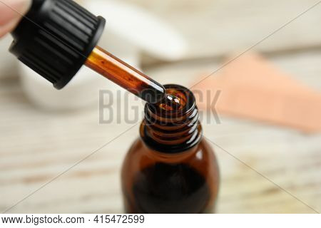 Dripping Medical Iodine From Pipette Into Glass Bottle, Closeup
