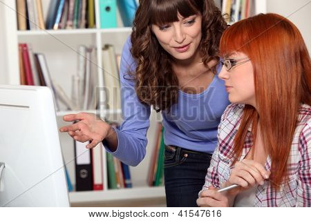 To kvinder studerer sammen i biblioteket