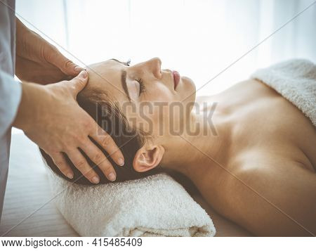 Beautiful Brunette Woman Enjoying Facial Massage With Closed Eyes Comfortable And Blissful. Relaxing