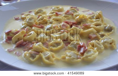 Talíř Tortellini se smetanovou omáčkou a šunkou.