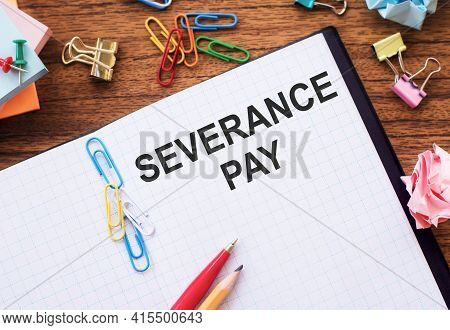 Notepad With The Text Severance Pay On The Table With Colored Paper Clips And Crumpled Sheets.
