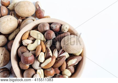 Assorted Nuts In Ceramic Dishes And Nuts Scattered On A White Background Top View Assorted Nuts