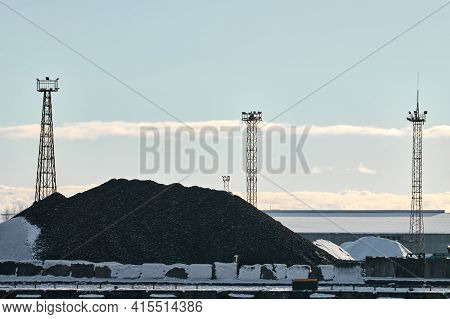 Coal Heap, Natural Black Coal, Product Of Mining And Three Towers With Searchlights. Industrial Land