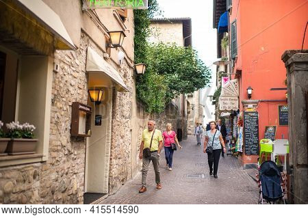 Sirmione, Italy-october 9, 2018: People Relax In The Town Of Sirmione Near The Castle Of Scaligera