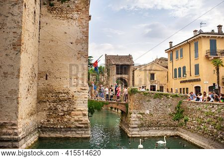 Sirmione, Italy-october 9, 2018: People Relax In The Town Of Sirmione Near The Castle Of Scaligera