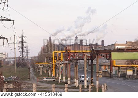 Smoke Chimneys On A Large Industrial Complex. High-voltage Power Lines, And Production Workshops.