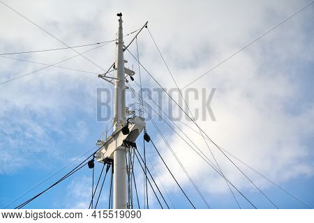 Sailing Mast Of Ship On Blue Cloudy Sky Background, Copy Space. Sailing Vessel Main Topgallant Mast.