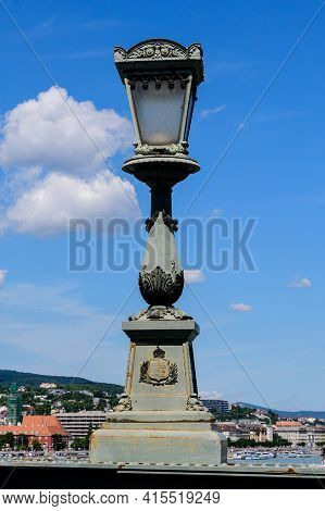 Vintage Rusted Lighting Pole With Clear Blue Sky In The Background On Széchenyi Chain Bridge Over Da