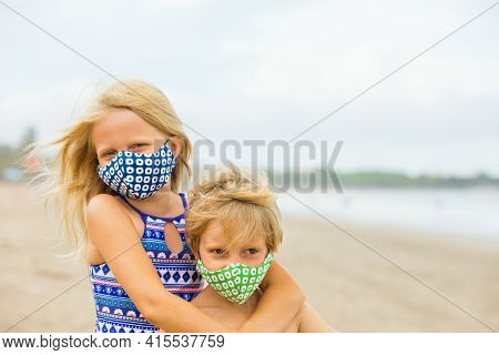 Children In Stylish Masks Have Fun On Sea Sand Beach. New Rules To Wear Face Covering At Public Plac