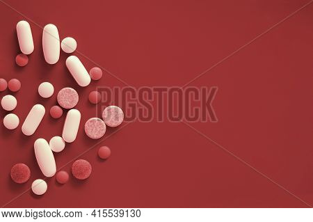 Medicine Pills On Bloody Red Background With Copy Space.