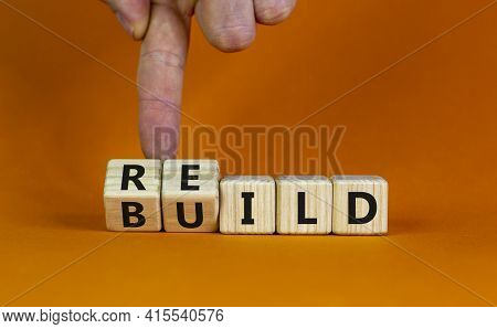 Rebuild Symbol. Concept Word 'rebuild' On Wooden Cubes On A Beautiful Orange Table. Businessman Hand