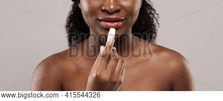 Lip Care. African Female Using Chapstick To Moisturise Her Beautiful Plump Lips