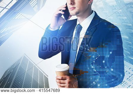 Businessman Wearing Formal Suit Is Holding A Coffee Cup And Having Conference Call Via Smart Phone. 