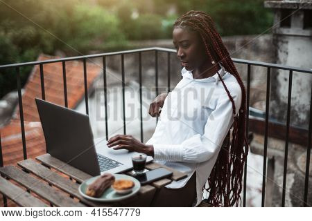 A Portrait Of A Young Drop-dead Gorgeous Black Woman Freelancer With Long Braided Hair And White Shi