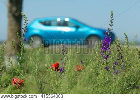 Bright Blue Car And Spring Flowers On The Foreground. Road Trip Concept. Spring, May, Cremea