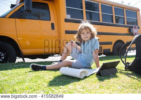 Back To School. Happy Child Study In Park Near School Bus. Schoolboy Doing Homework Or Online Educat