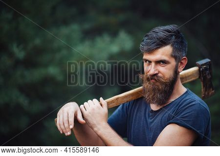 Stylish Brutal Bearded Man In A Dark Sleeveless T-shirt With A Large Mustache And Gray Hair Holding