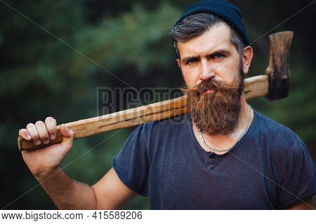 Stylish Brutal Bearded Man In A Dark Sleeveless T-shirt With A Large Mustache And Gray Hair Holding 