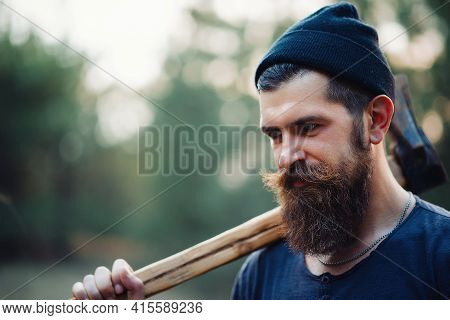 Close-up Portrait Of A Brutal Bearded Man In A Dark Sleeveless T-shirt With A Large Mustache And Gra